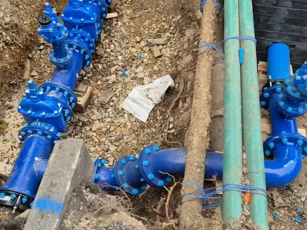 Blue gate-valve assembly on a water main alongside service ducts