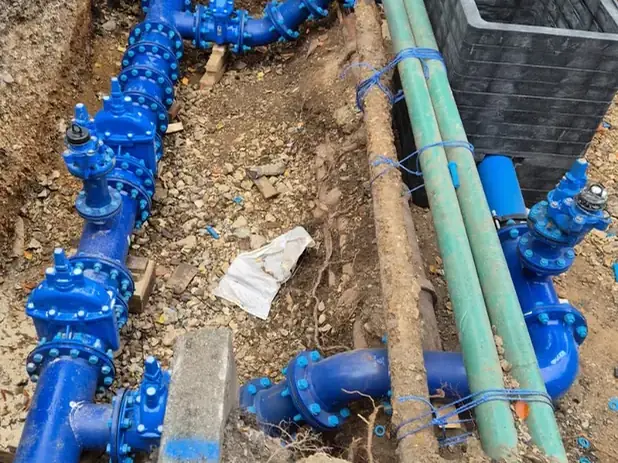 Blue ductile-iron water main and valve assembly in an open trench