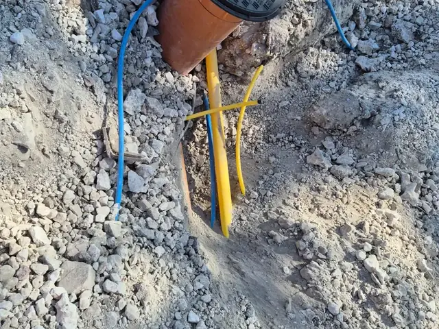 Clay drainage pipe and capped service pipes in an open excavation