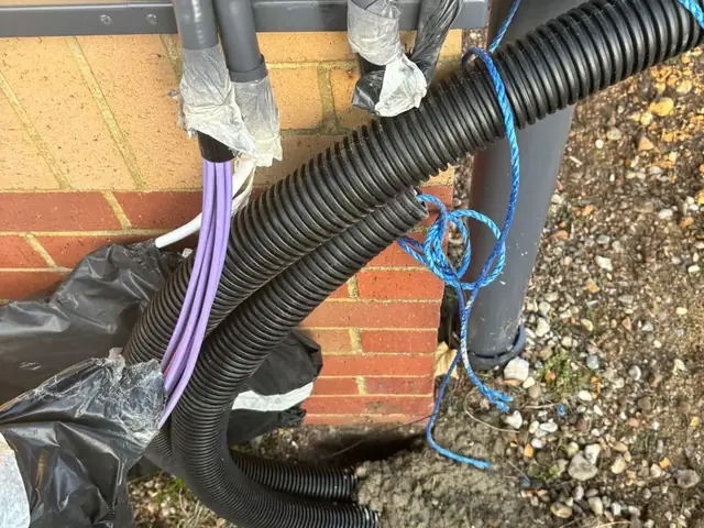 Cable ducting and service cables run up to the meter position at a Burger King drive-thru