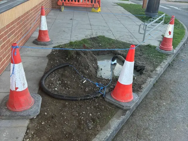 Excavated cable trench and ducting on the forecourt of a Burger King drive-thru