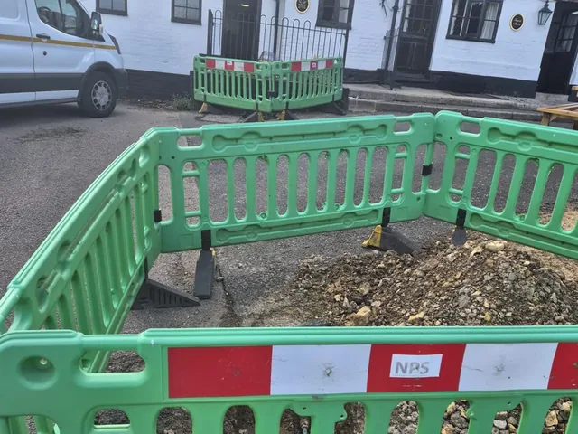 Barriered excavation in the road outside a village pub for a customer supply pipe renewal