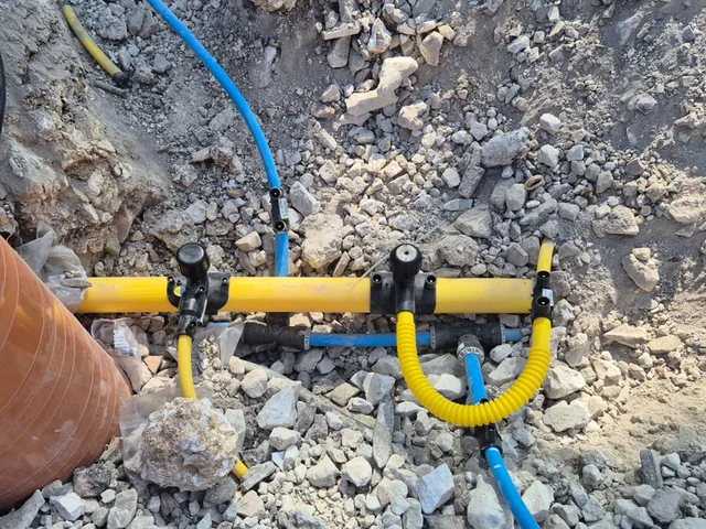 Gas and water services teed off side by side on a new-build connection