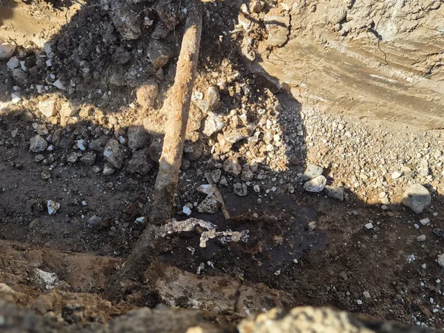 Corroded iron pipe exposed in an excavation before repair