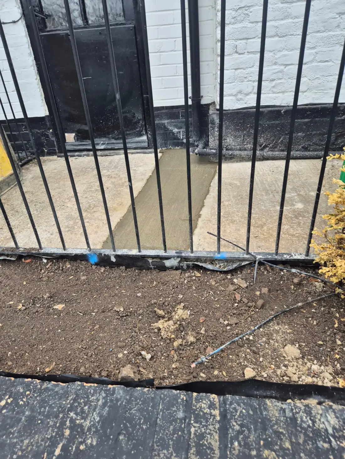 The concrete path reinstated behind the pub railings after the new supply went in The concrete path reinstated behind the pub railings after the new supply went in