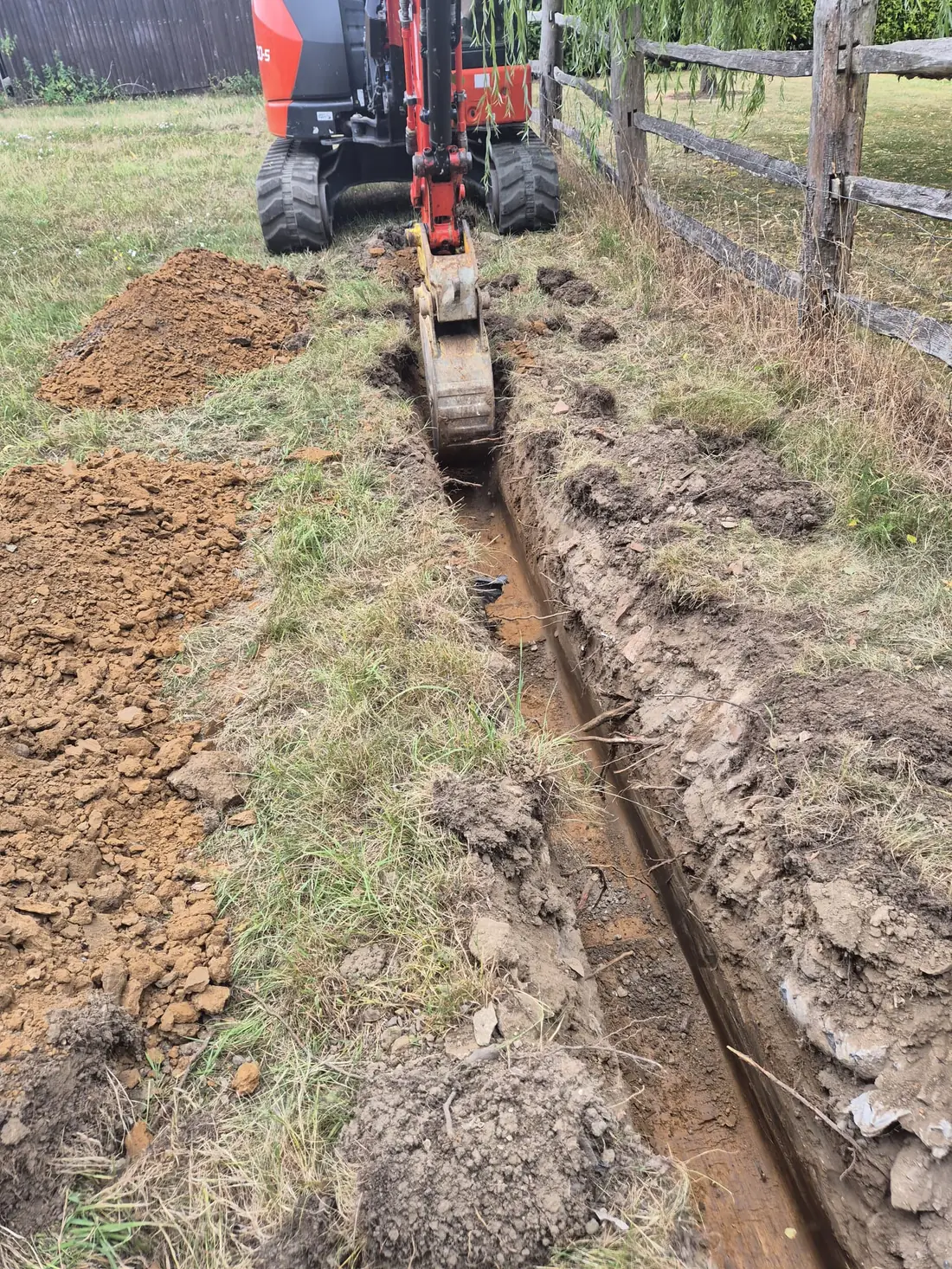 The new supply pipe brought up at the fence corner, bedded in sand The new supply pipe brought up at the fence corner, bedded in sand